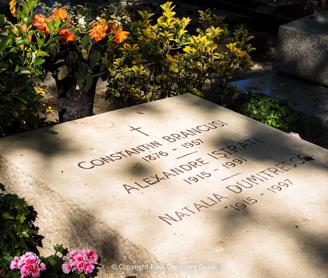 Colorful bouquets of flowers on one of the newer tombs at Pere Lachaise Cemetery