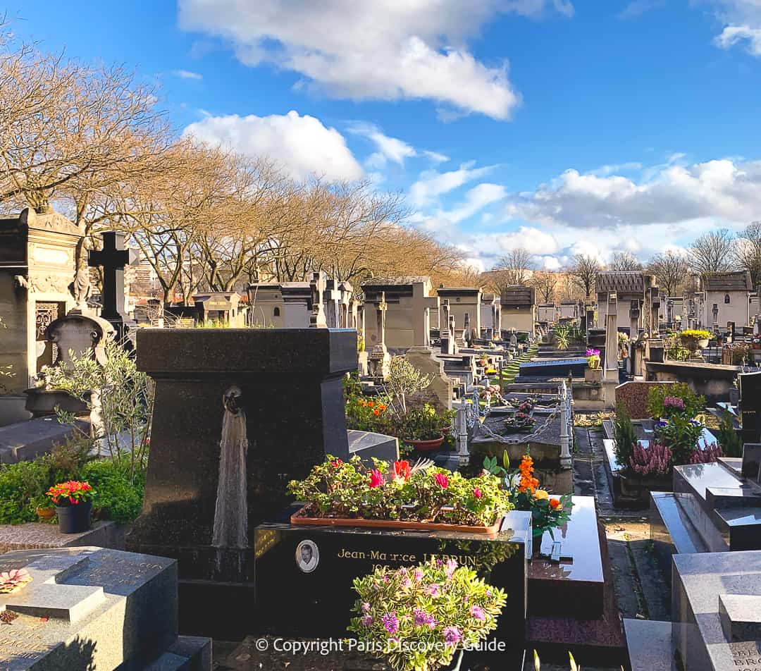 Colorful bouquets of flowers on one of the newer tombs at Pere Lachaise Cemetery