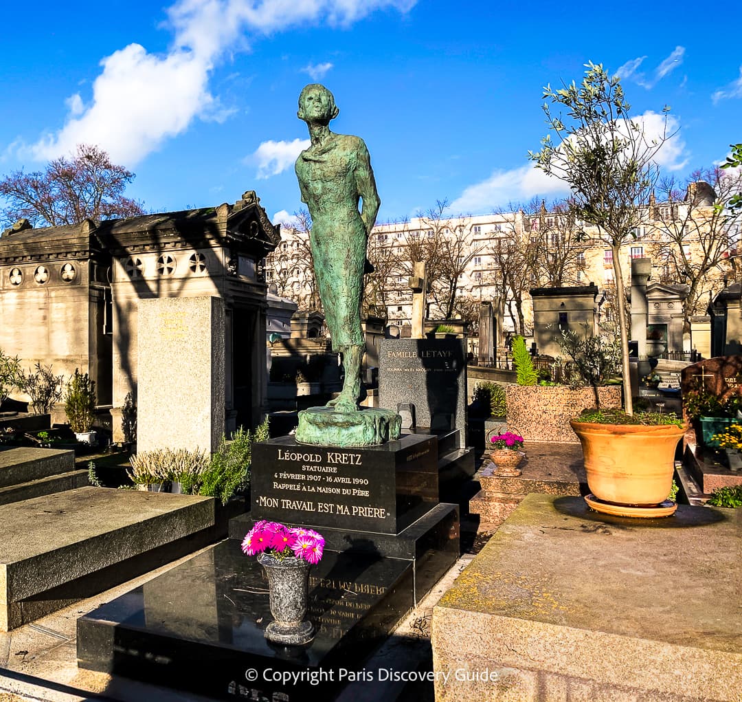 Colorful bouquets of flowers on one of the newer tombs at Pere Lachaise Cemetery