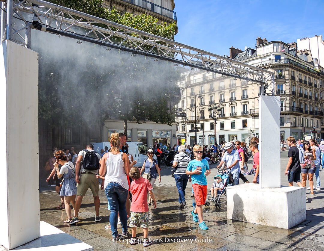 Shoppers from nearby rue de Rivoli walk over to cool off under the mist fountain - another popular feature at the Paris City Hall "beach" 