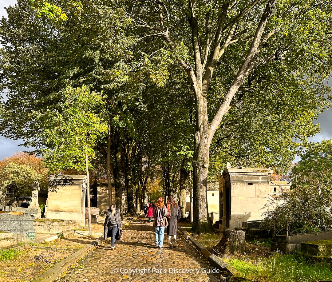 People walking along path at Pere Lachaise Cemetery