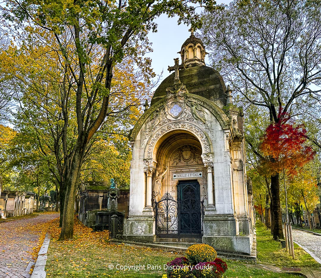 Colorful bouquets of Toussaint flowers in front of a family tomb at Pere Lachaise