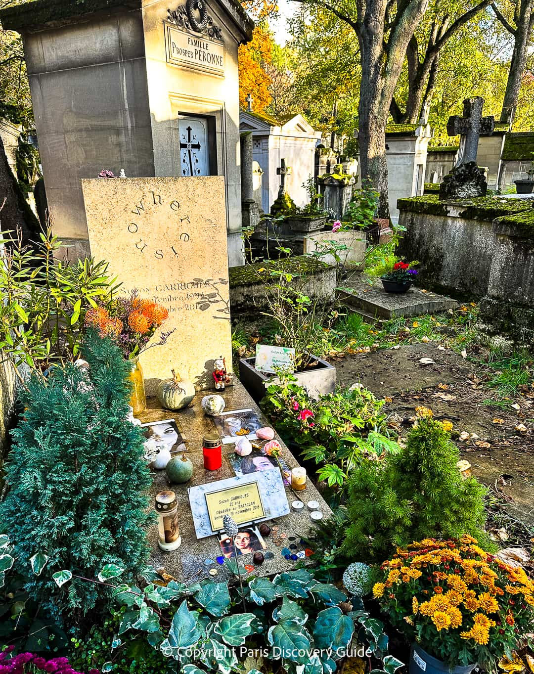 Candles and chrysanthemums on the grave of Suzen Garrigues, who was 21 when she was killed during the attack on the Bataclan