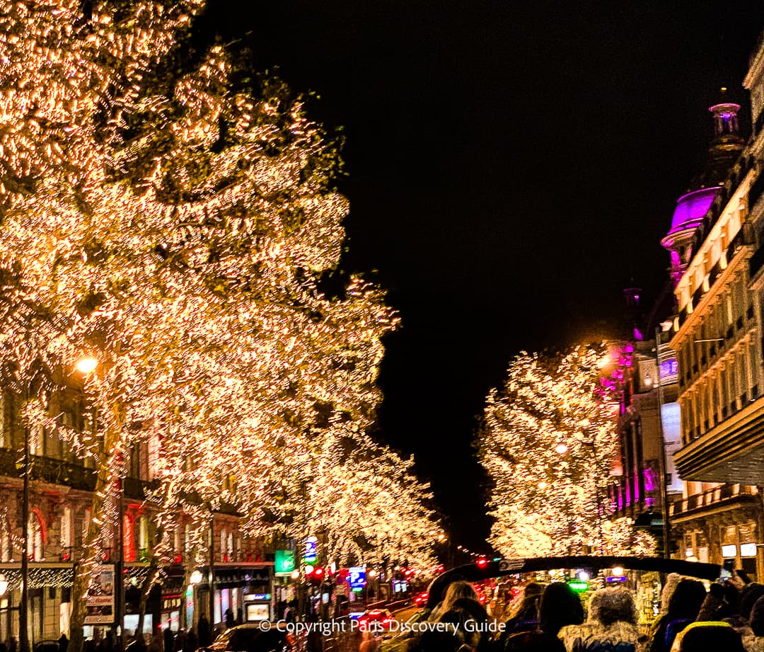 Christmas Lights tour bus passing Printemps Haussmann